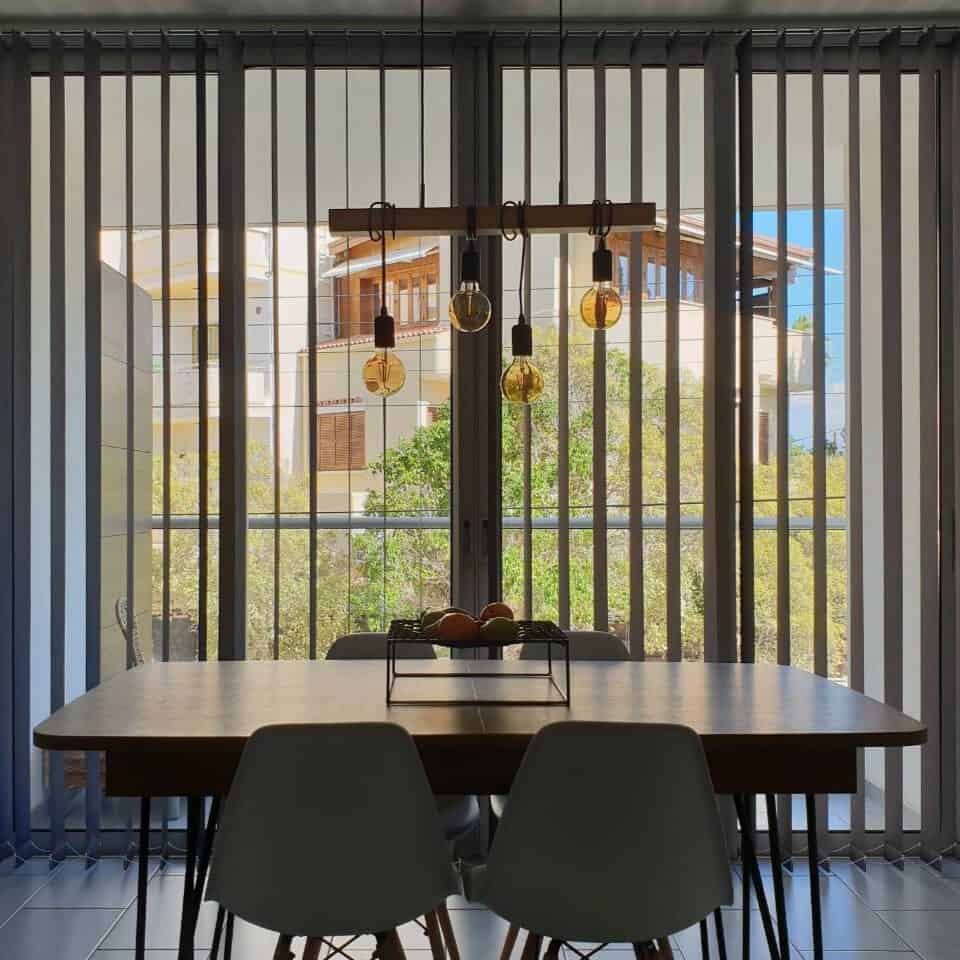 Grey vertical blind with blackout fabric, for an apartment's dining area