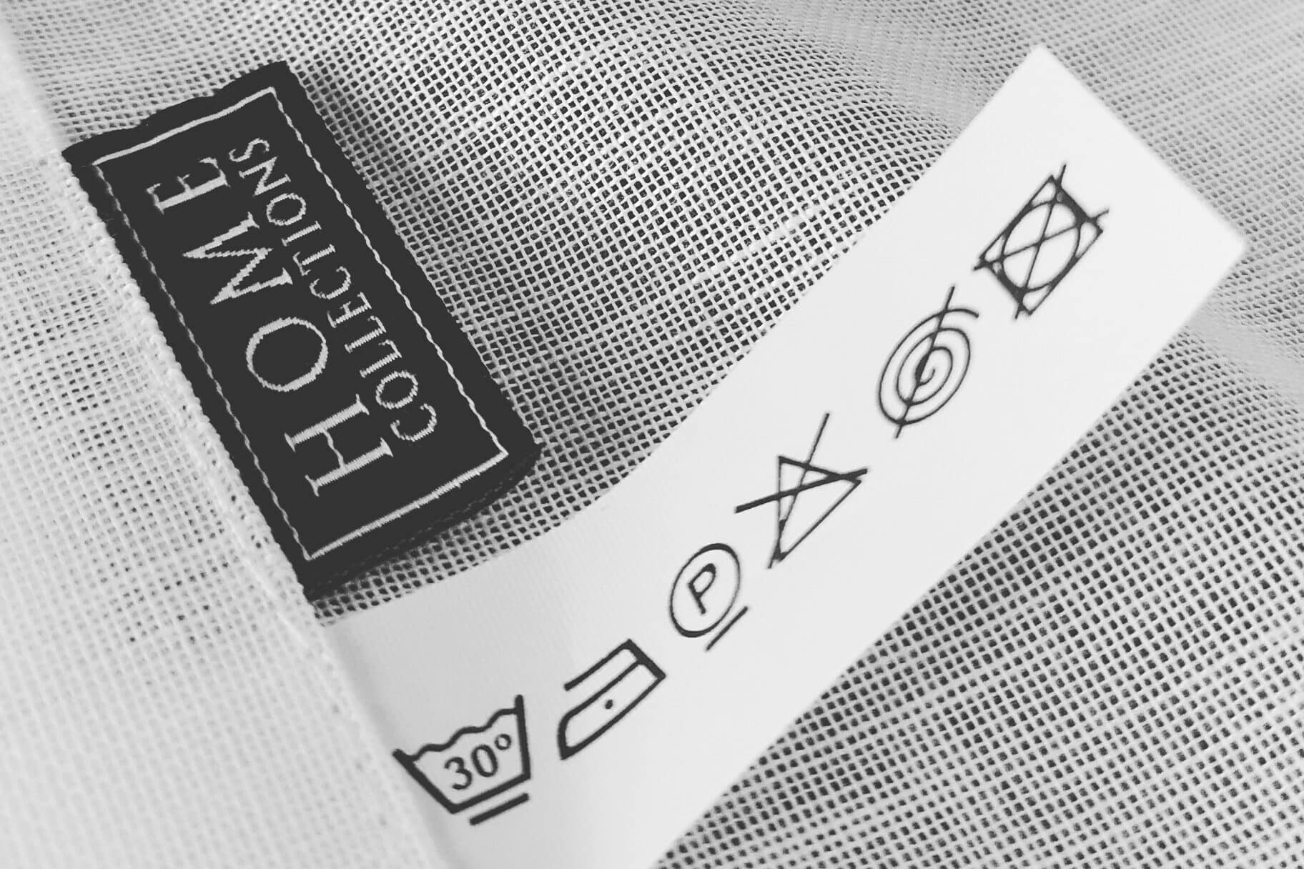 A cleaning label attached to a curtain, along with the Home Collections logo