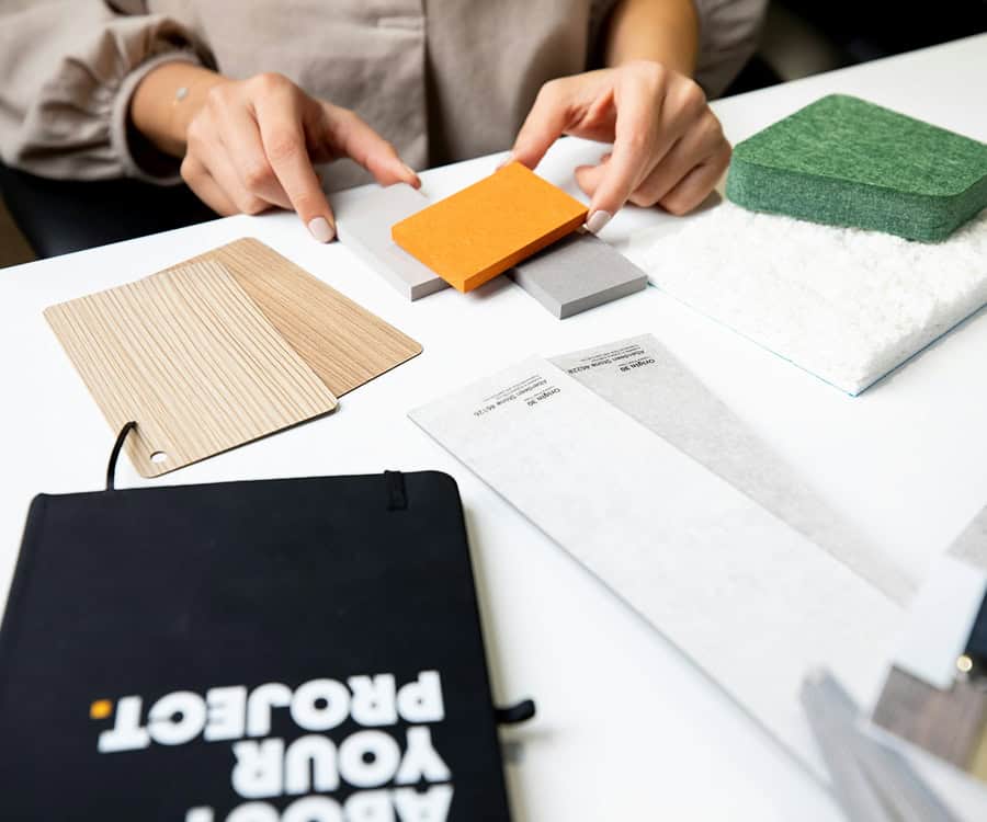 a professional's desk with notebook, fabric samples and measurements